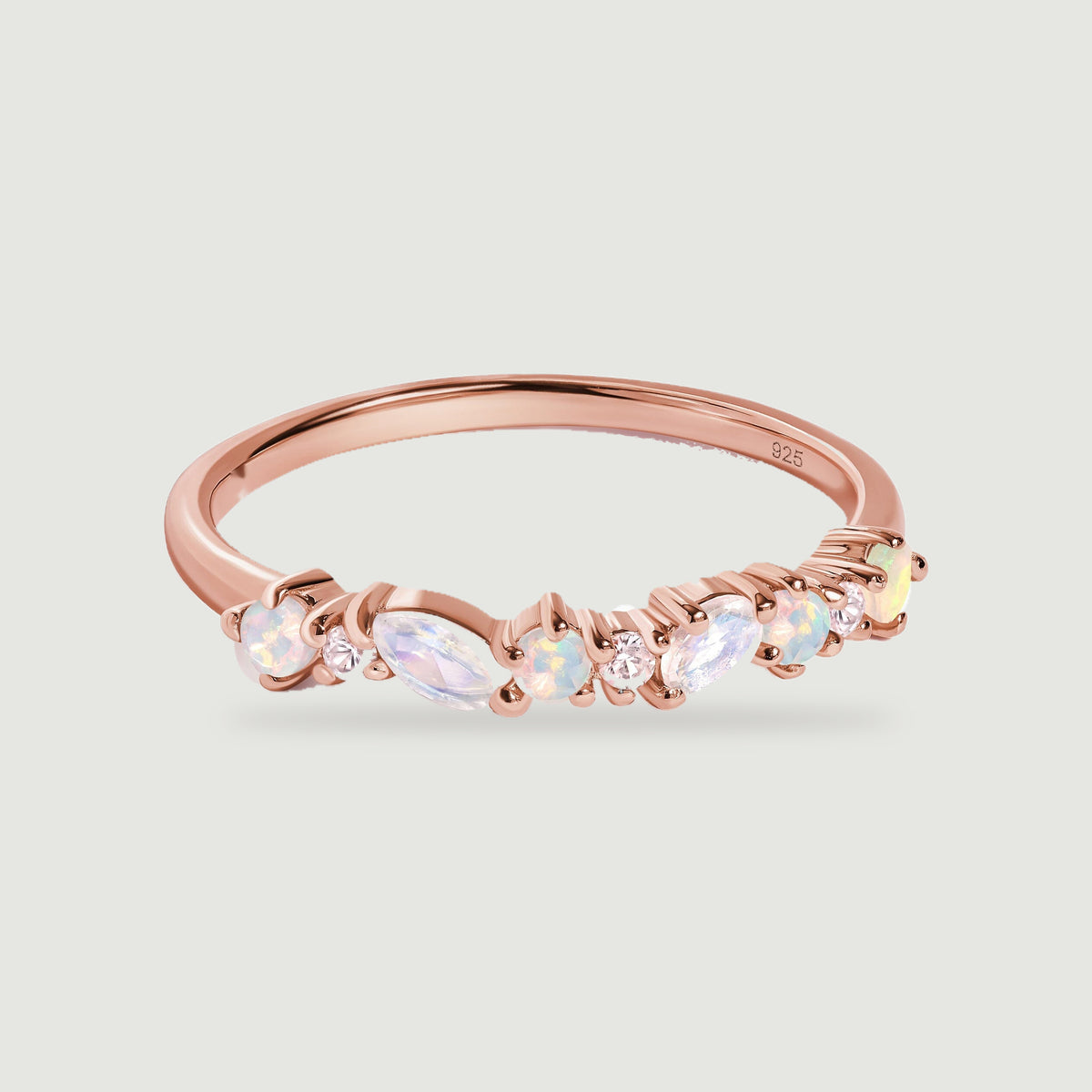 A rose gold ring combines alternating round and marquise gemstones along a slender band.