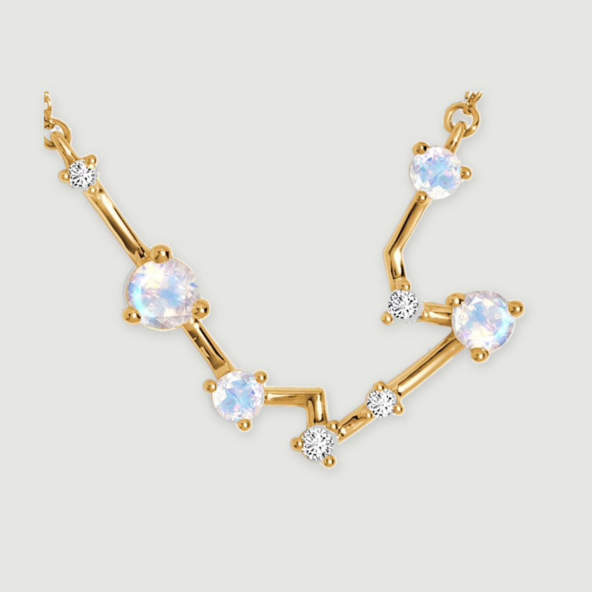 A close view shows yellow gold settings, pale faceted moonstones, and bright clear accents across the curved pendant.