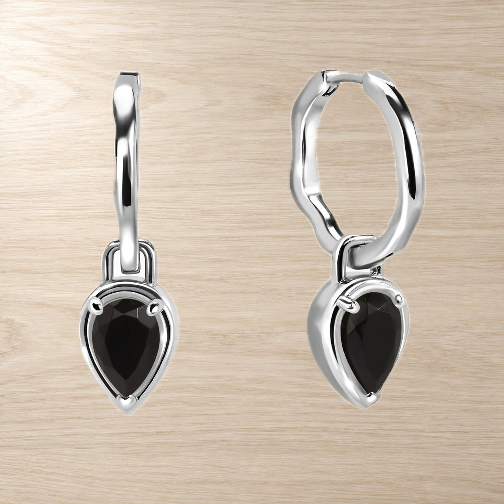 Pair of pear-shaped black onyx drop hoop earrings displayed against a light wood background.