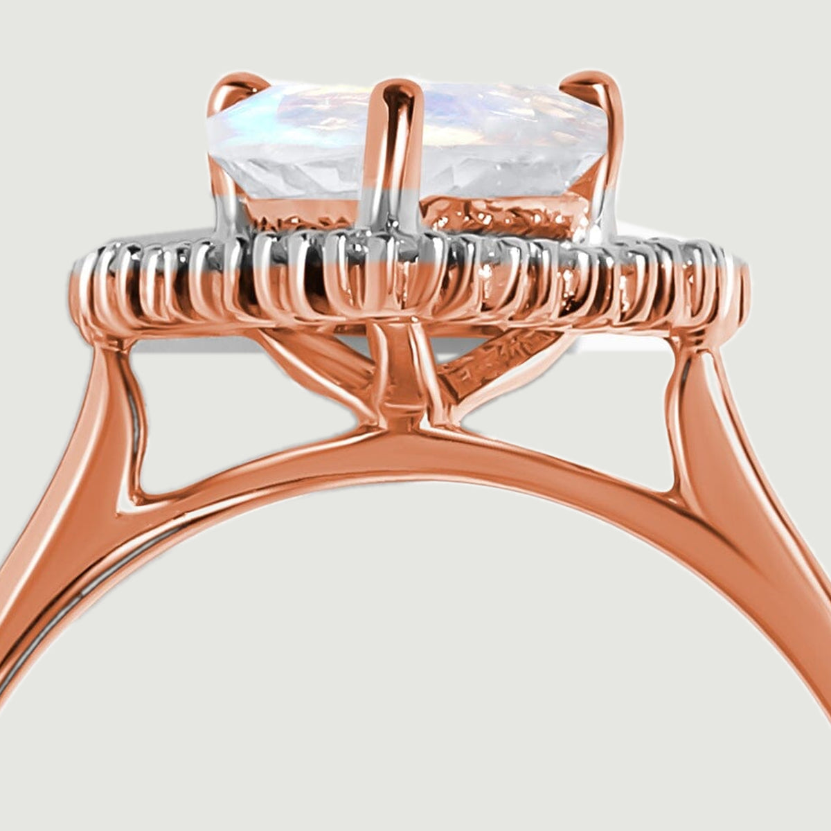 A close side view reveals the faceted moonstone above the diamond rim and open rose gold gallery.