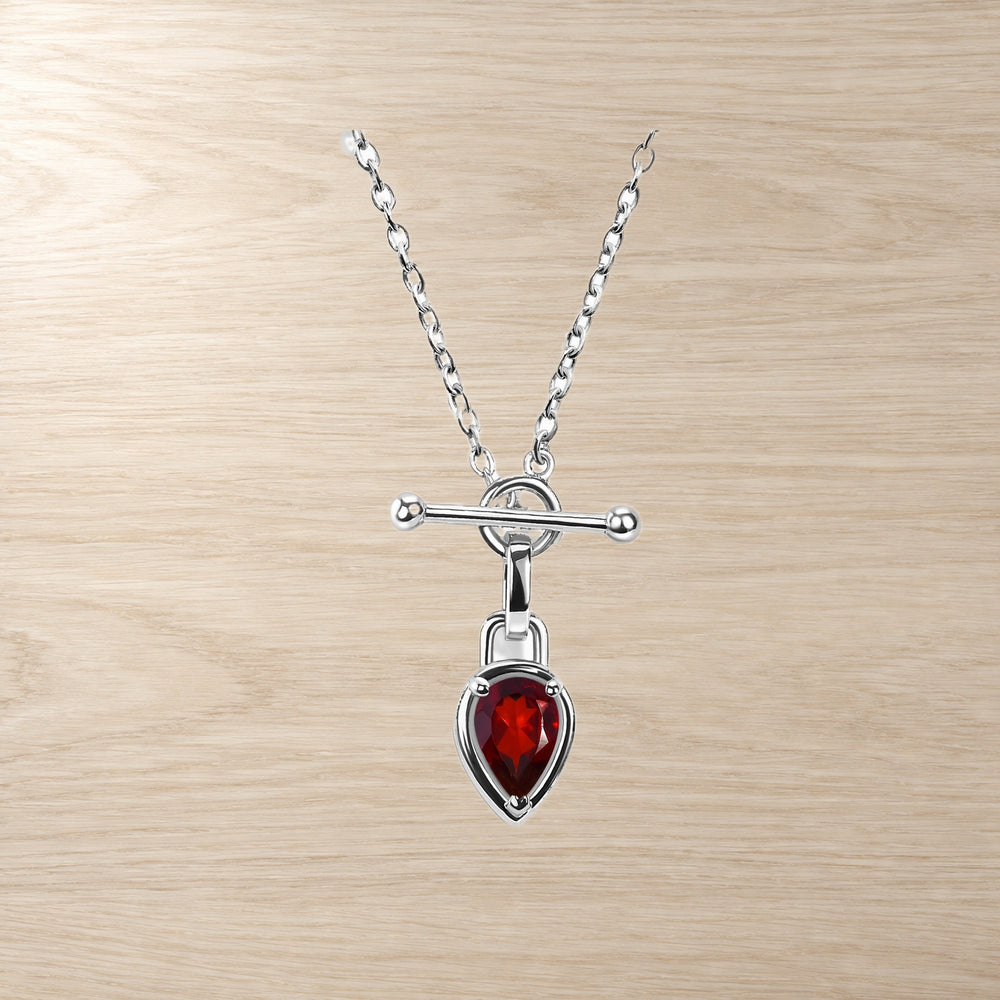 Garnet pear-shaped pendant necklace with a horizontal bar clasp displayed on a wood-grain background.
