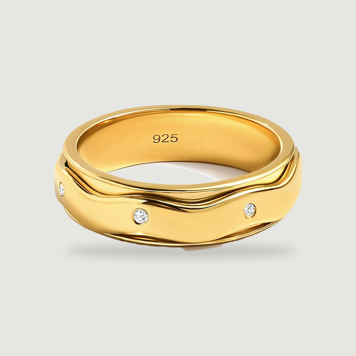 A yellow gold vermeil ring shows a smooth undulating band with small round white stones against a light gray background.