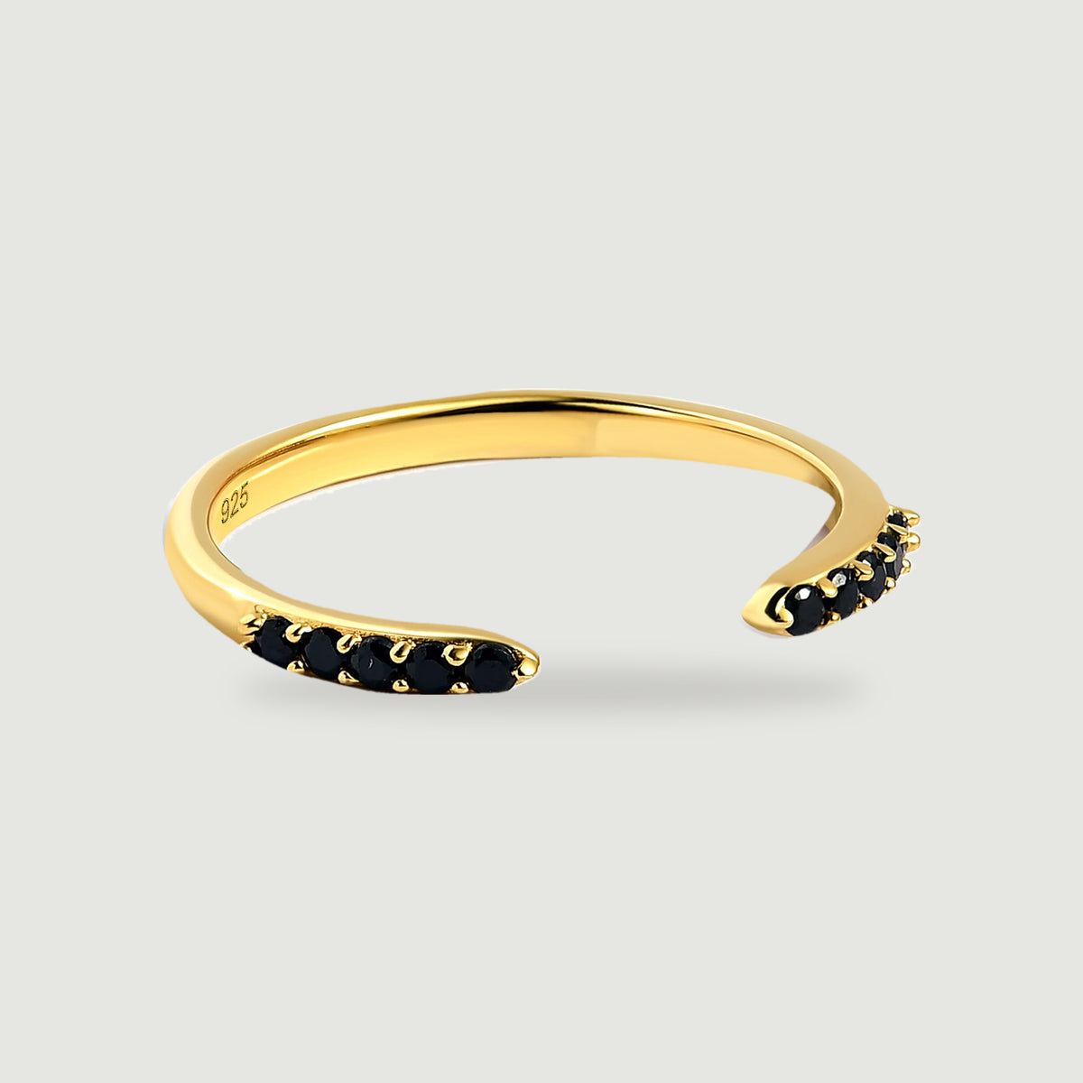 A yellow gold vermeil ring curves around an open gap between two rows of black stones.