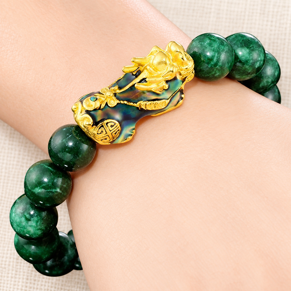 Close-up of the green jade and PiXiu bracelet worn on a wrist.