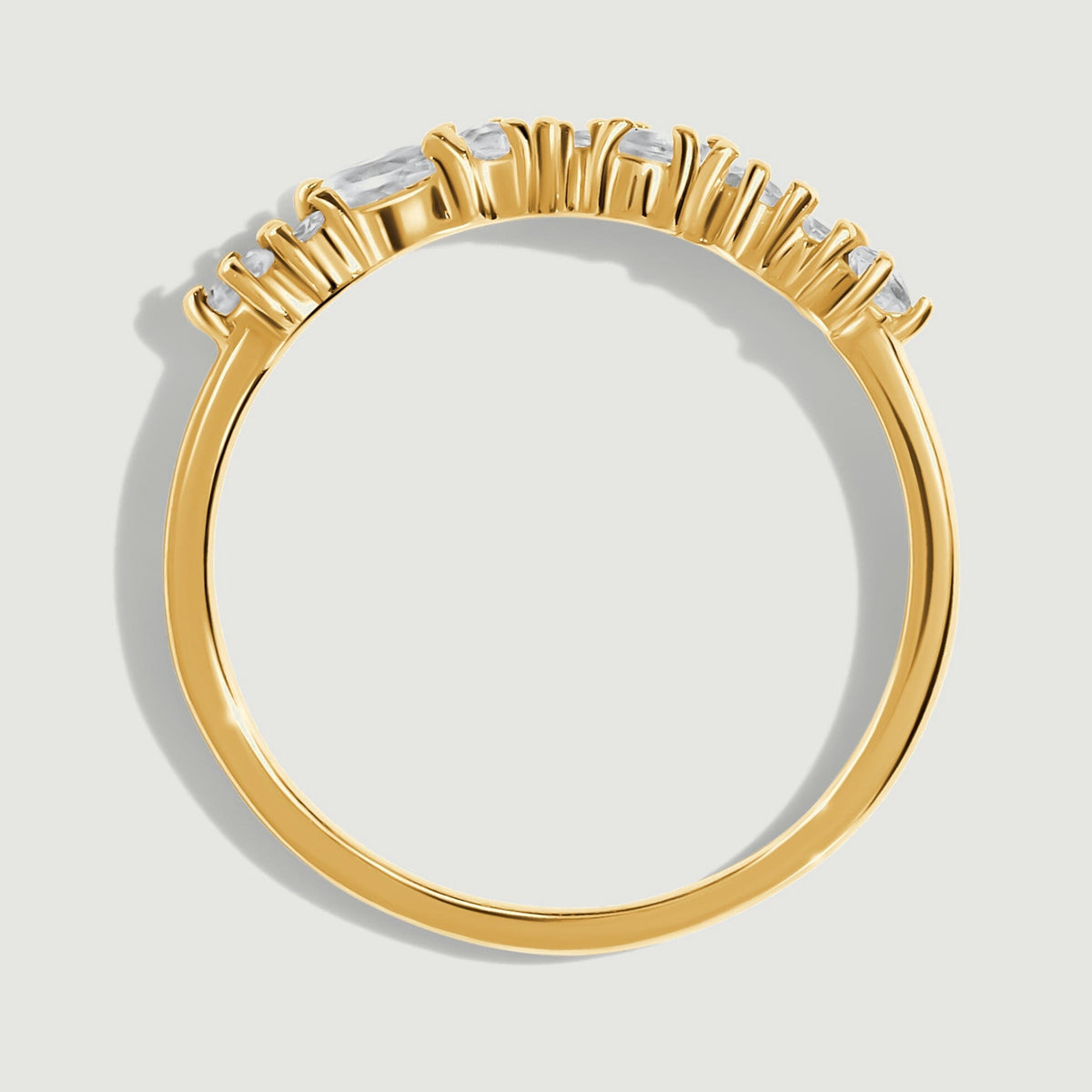Raised yellow gold settings sit above a narrow polished band in this side view.