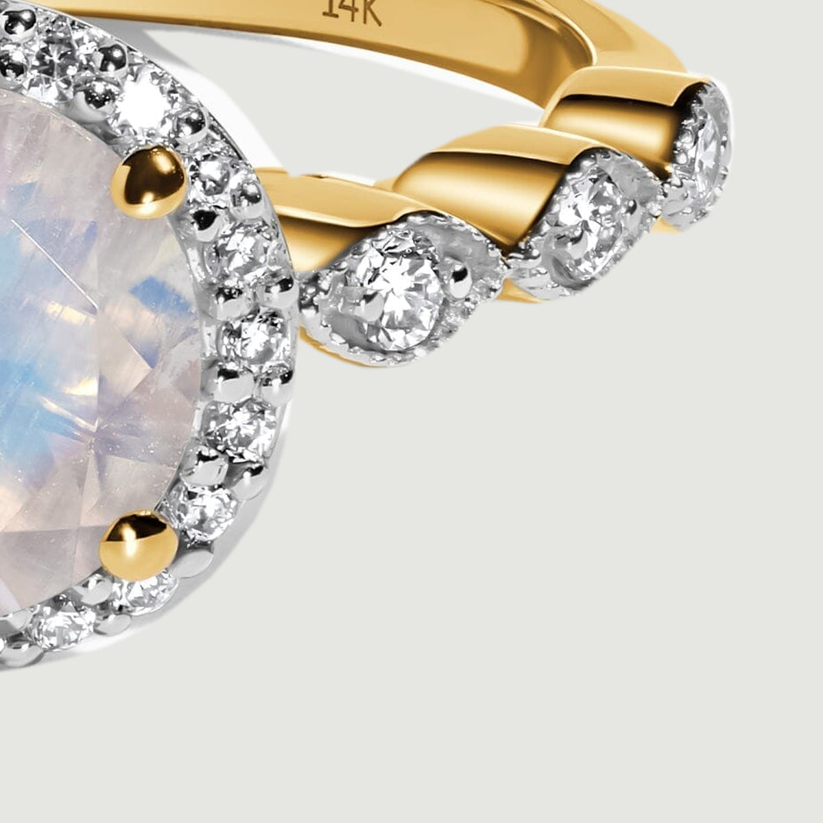 The right shoulder shows round diamonds and polished yellow gold beside the moonstone halo.