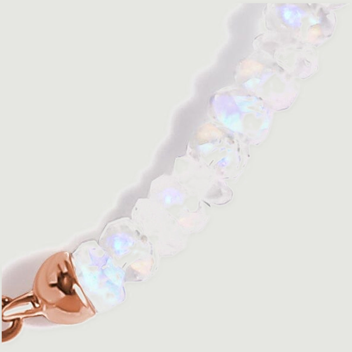 Several moonstone beads lead into a rose gold end cap and a small chain beside the clasp.