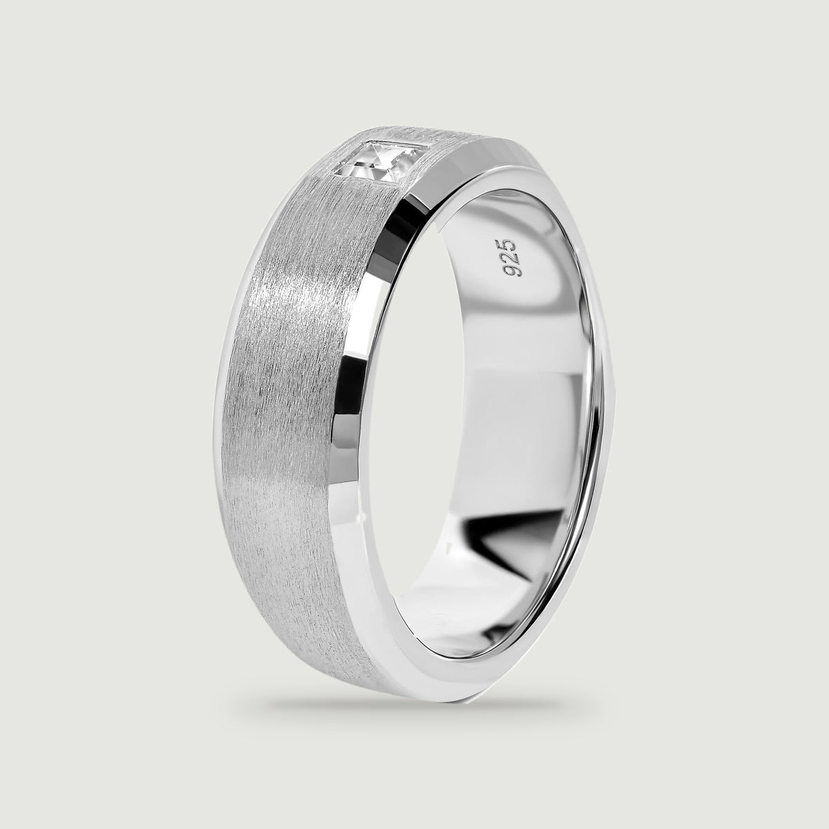An upright silver ring reveals its polished inner surface and brushed outer band.