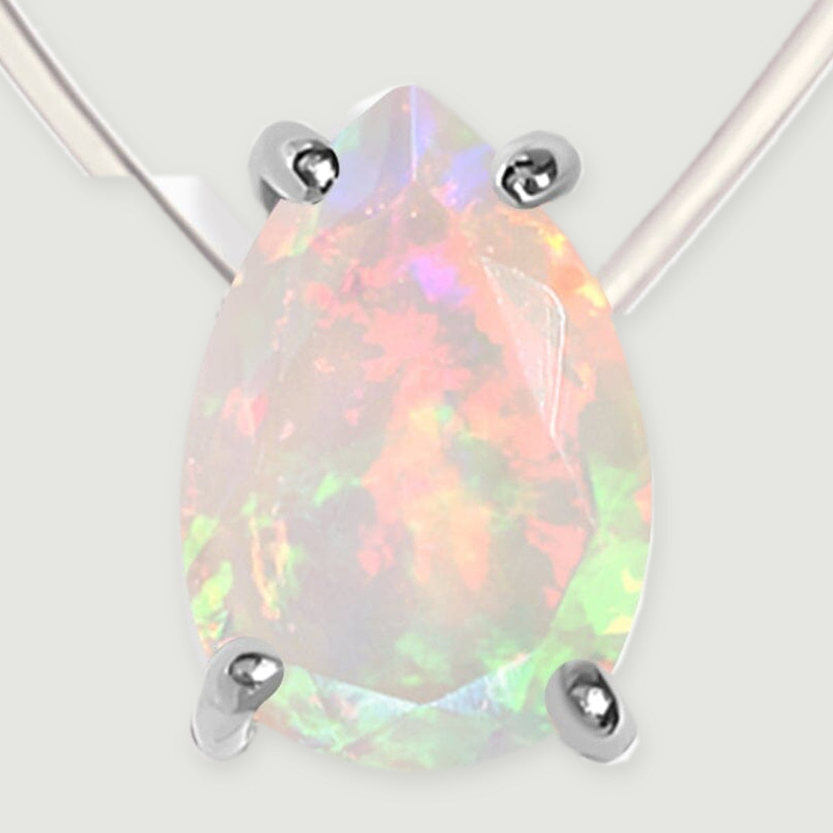 A close view shows the full pear-shaped opal and its four silver prongs against a light gray surface.