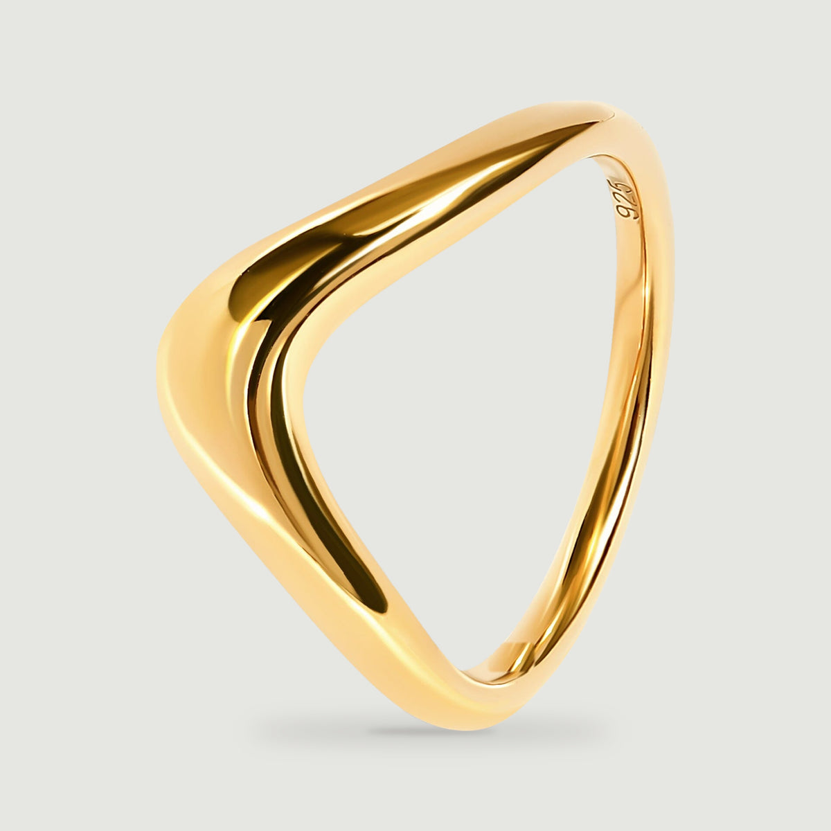 An angled yellow gold ring reveals its rounded shoulders and narrow rear band.