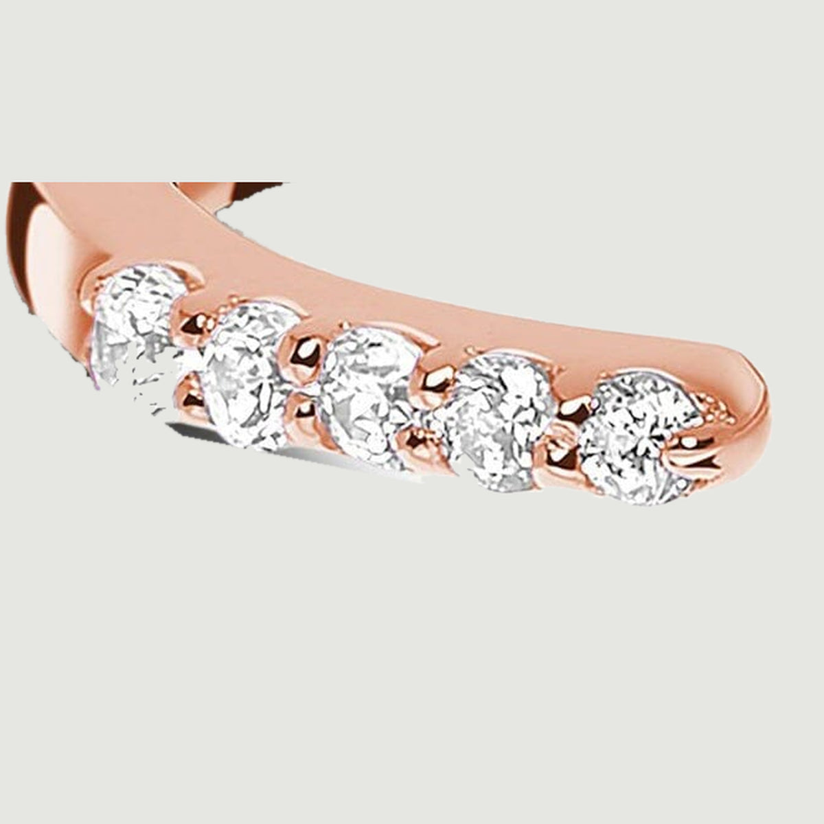 Five clear round diamonds sit in rose gold prongs along the left end of the open ring.