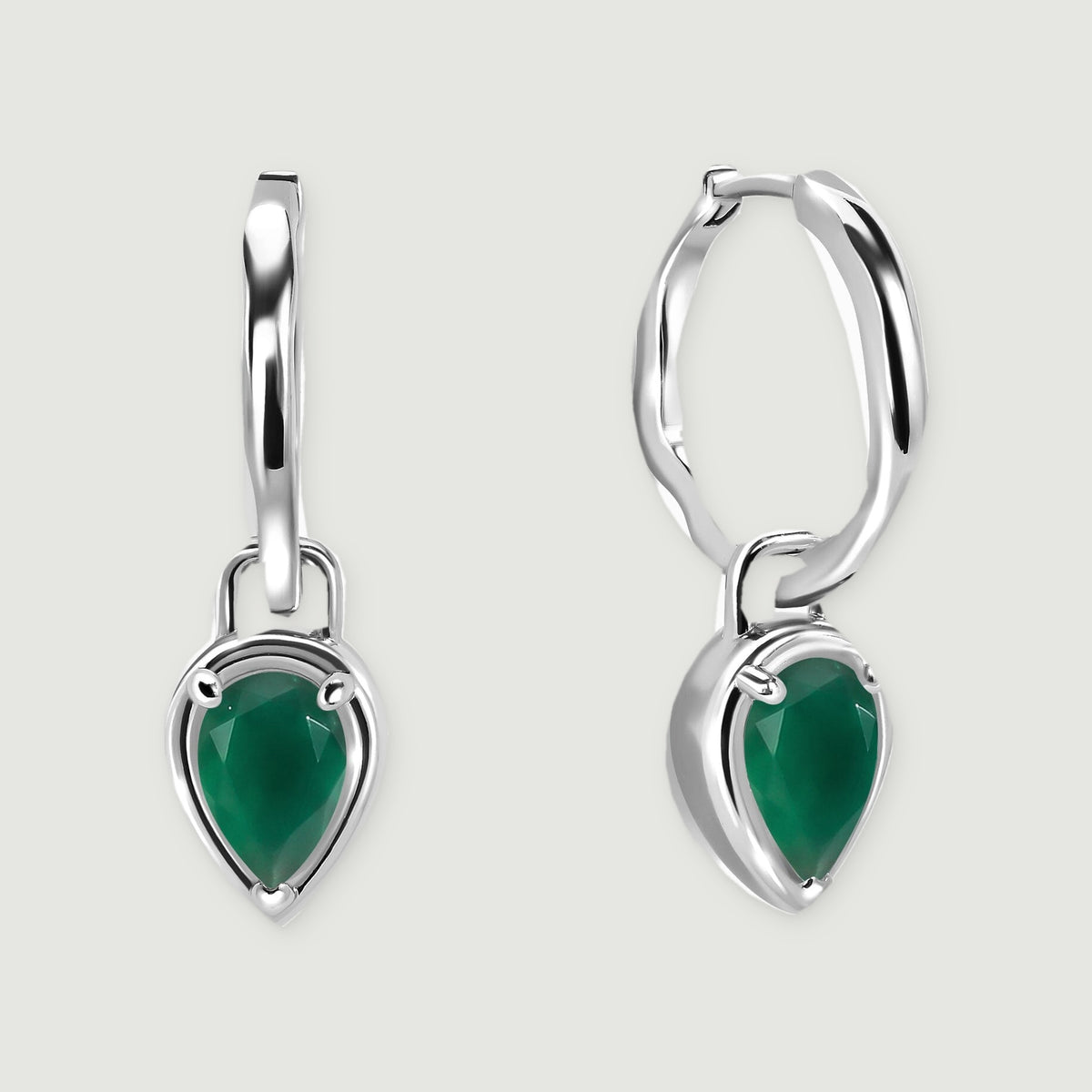 Two white rhodium plated hoop earrings carry faceted green pear drops against a light gray background.