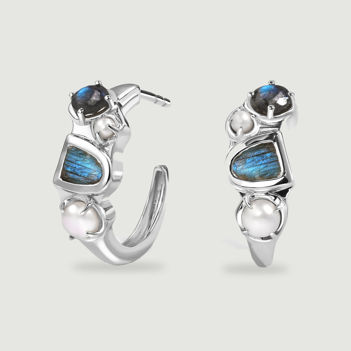 A pair of polished white rhodium hoops displays blue flashing labradorite and white pearls against a light gray background.