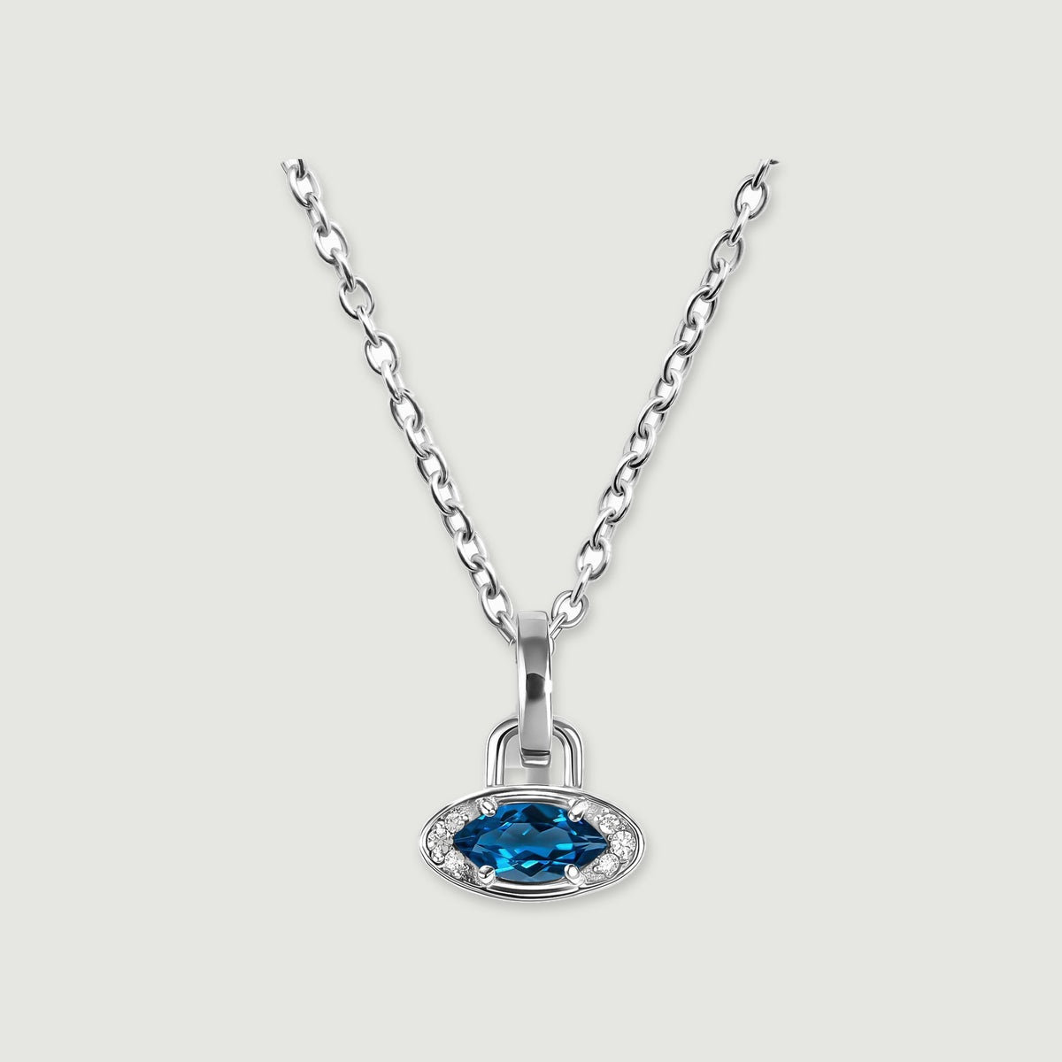 A white rhodium plated chain holds a horizontal blue topaz charm against a light gray background.