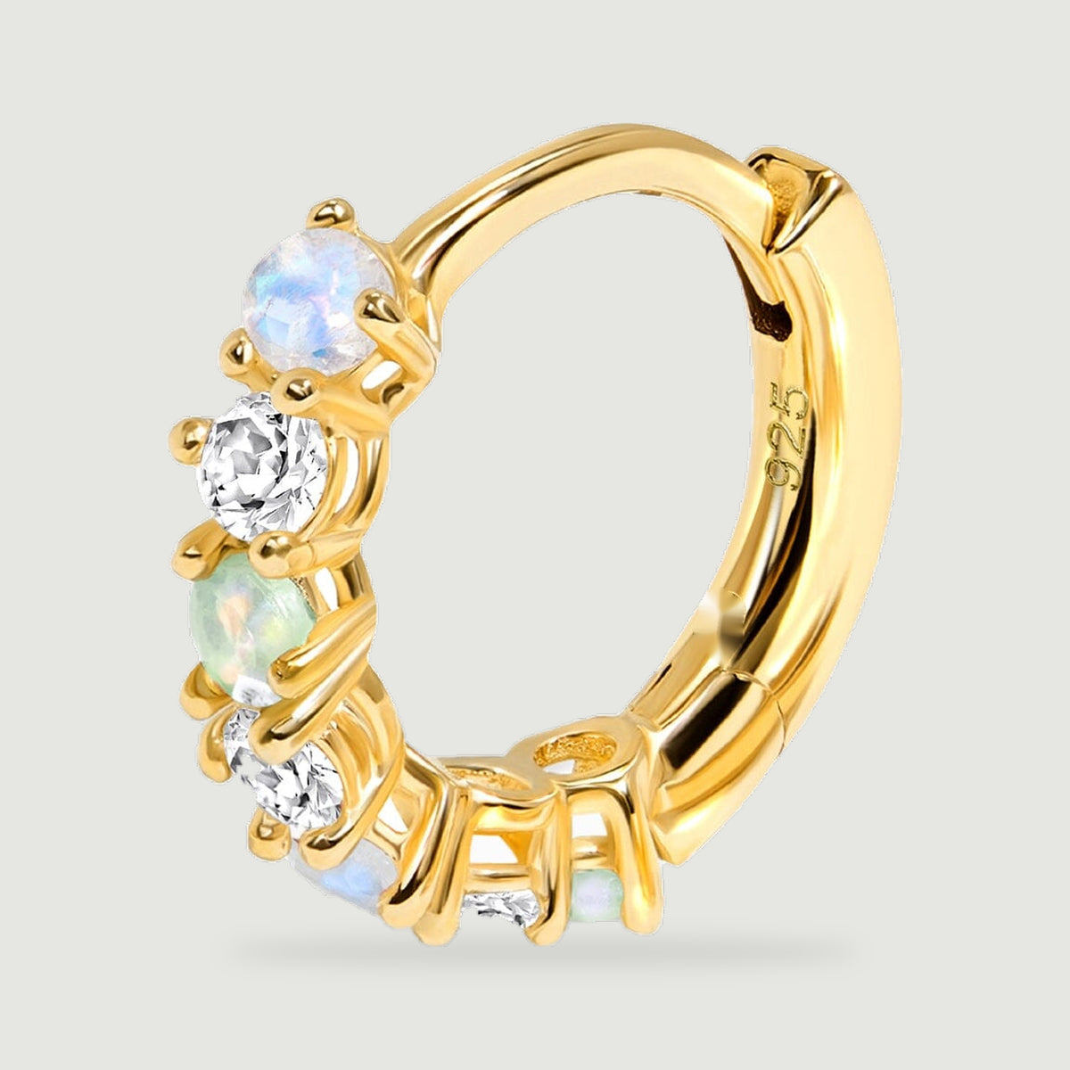 An upright yellow gold hoop reveals its curved inner band, hinged clasp, and prong set stones.