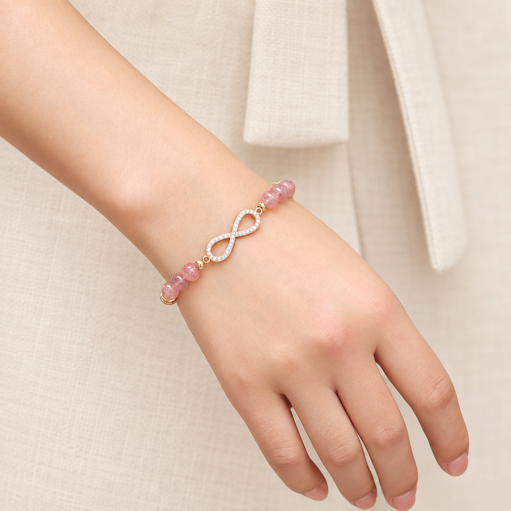 Pink bead infinity bracelet worn alone on a wrist.