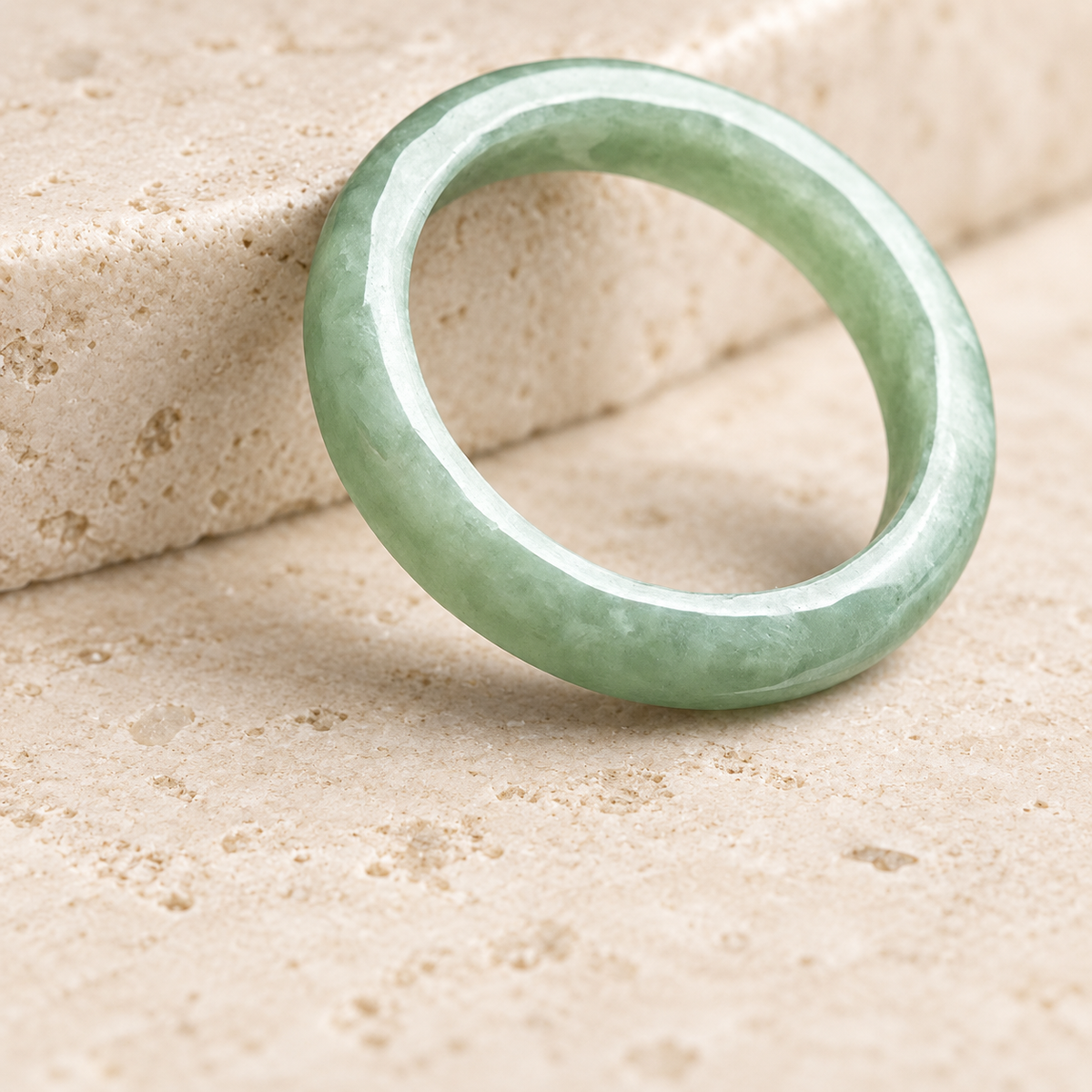 Pale jade ring leaning against a limestone support
