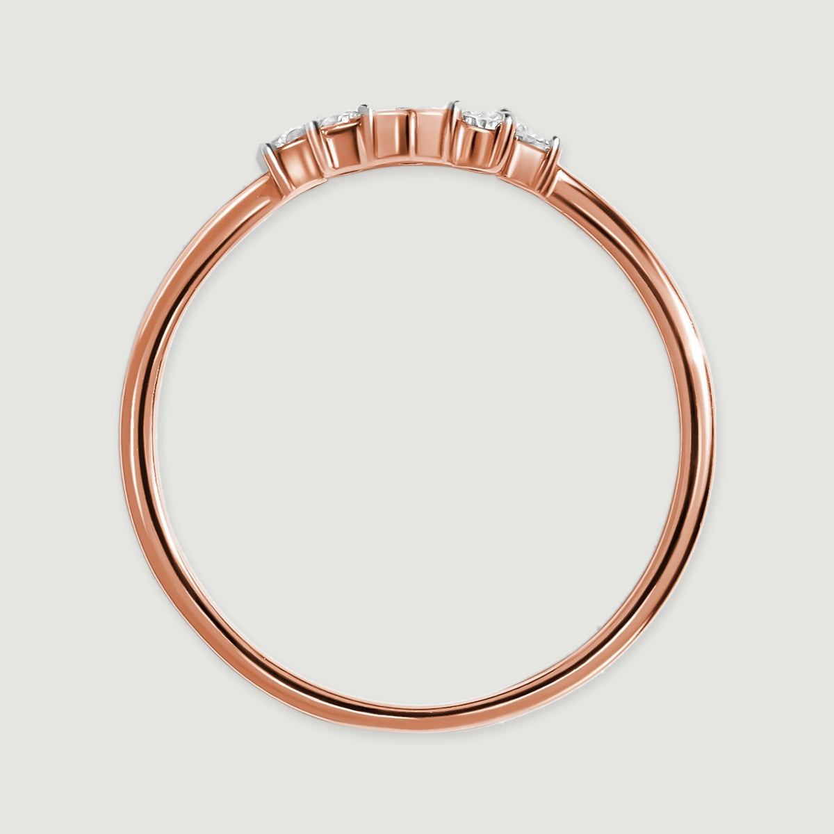 A rose gold ring is shown in profile with a smooth band below five raised stone settings.