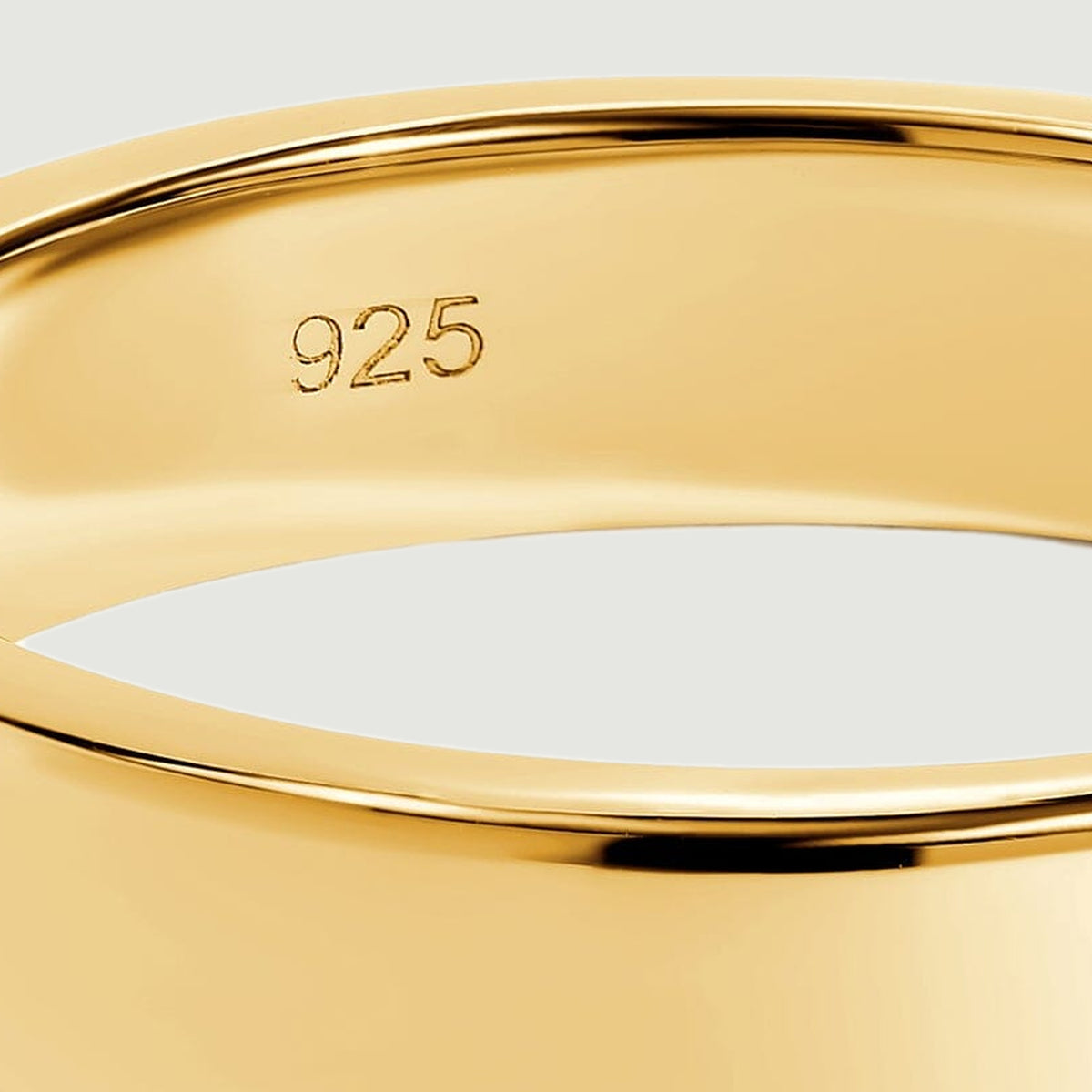 The inner 925 stamp and rounded upper rim are visible in a close view of the gold band.