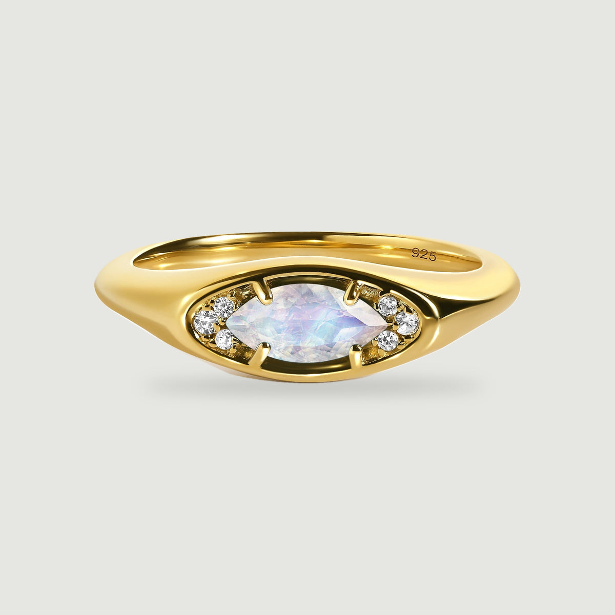 A yellow gold ring displays an eye-shaped setting with a faceted moonstone and clear accent stones.