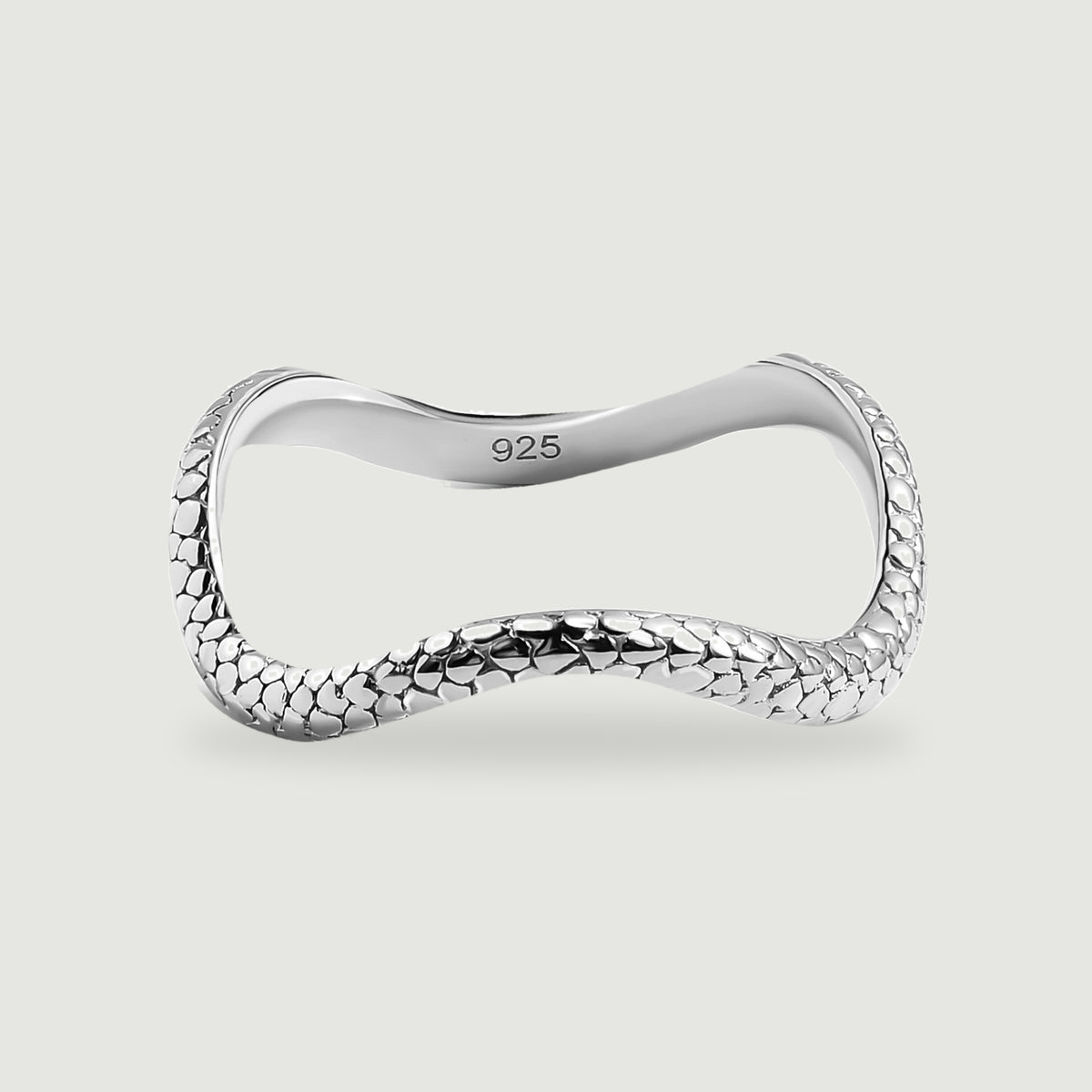 A complete polished silver ring has a curved band and raised oval texture on a light gray background.