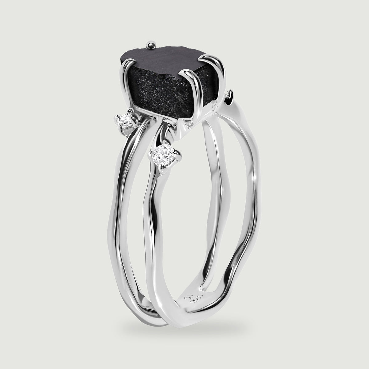 A side view of the sterling silver ring reveals its open band and polished stone claws.