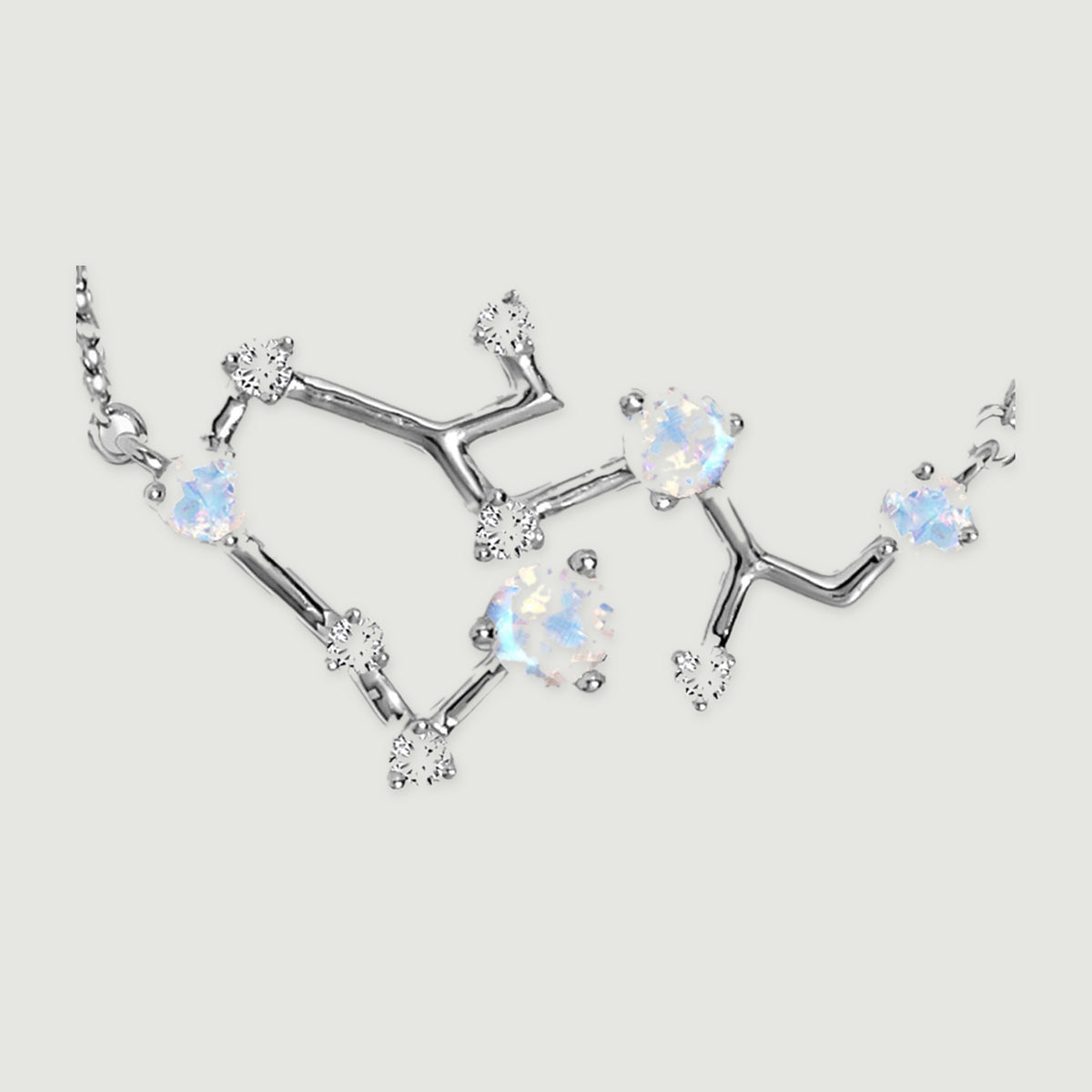 Silver prongs and polished connecting bars surround pale blue and clear stones in this pendant close-up.