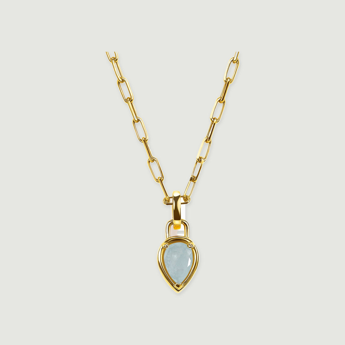 A yellow gold-colored link necklace with a pale blue pear-shaped pendant is centered on a light gray background.