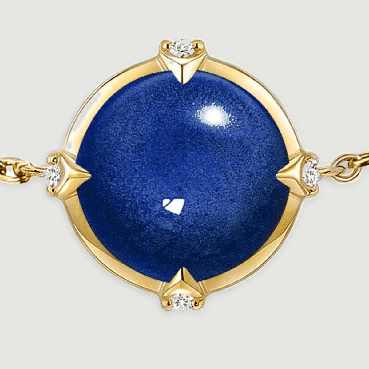 A close view shows the blue domed stone, four clear accents, and yellow gold tone rim of the bracelet.