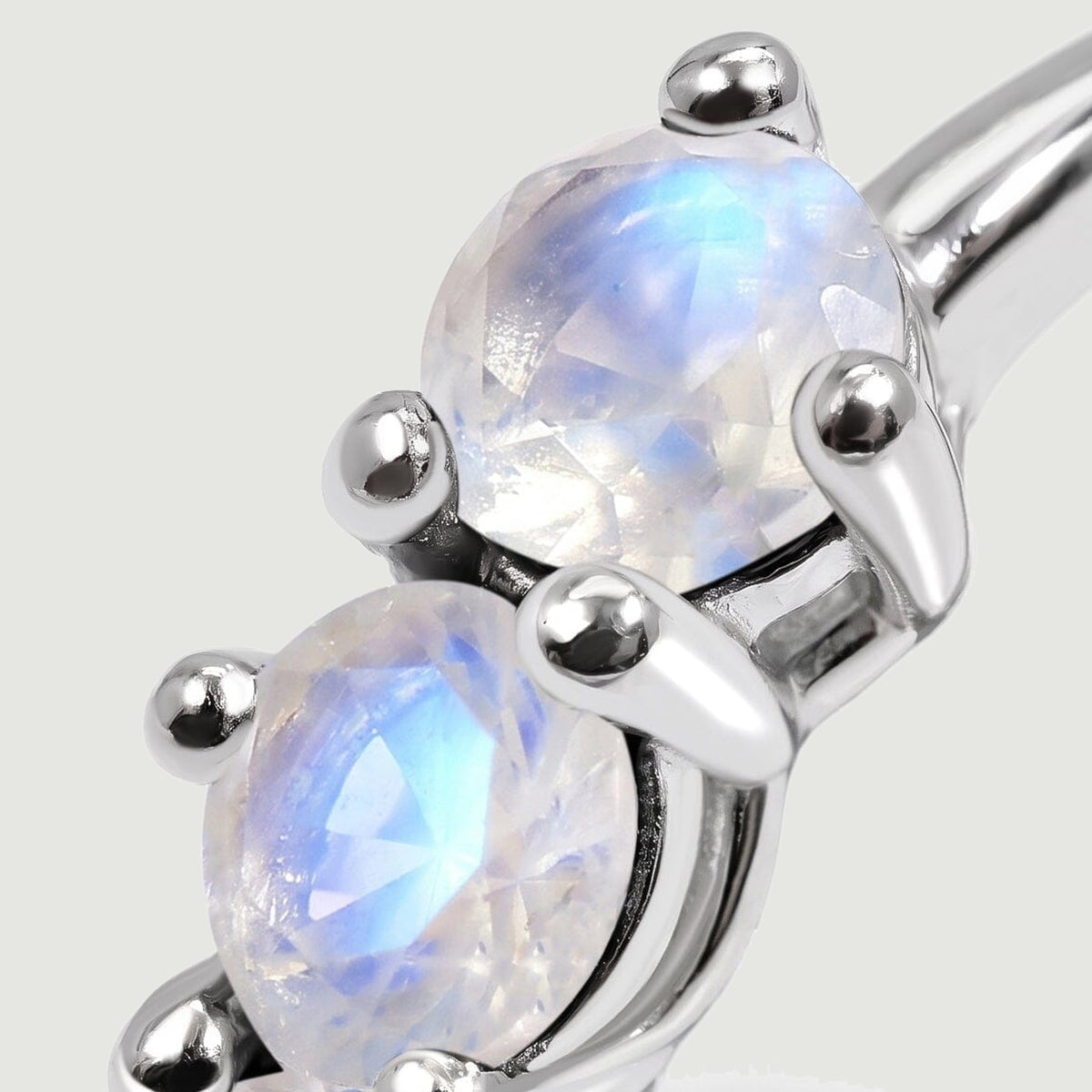 Faceted moonstones show pale blue reflections between rounded silver-tone prongs.