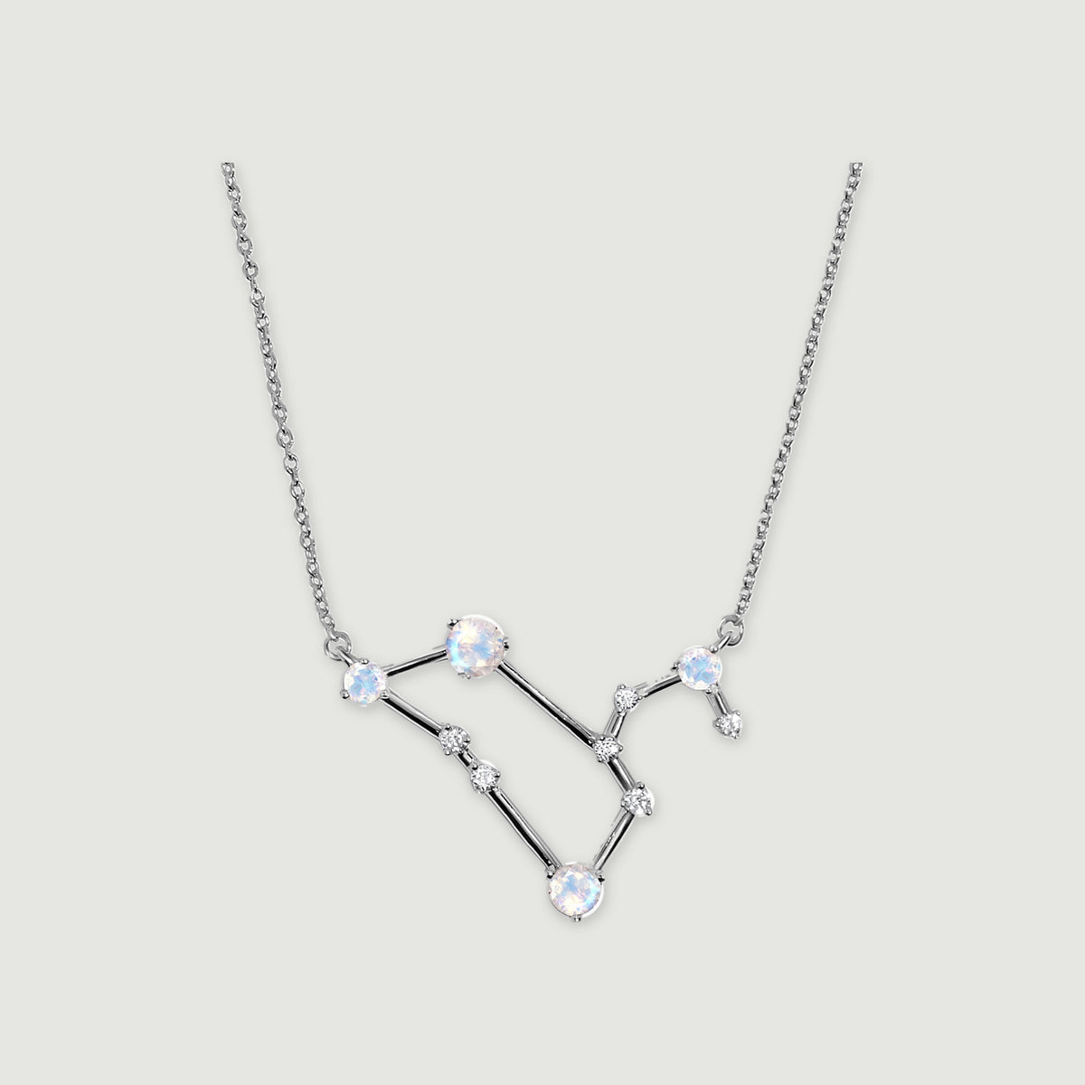 A silver necklace shows round iridescent moonstones and clear accents connected by polished angular bars.