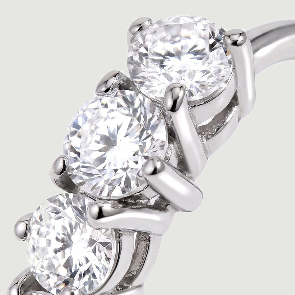 A close view shows round white topaz facets held by polished silver-tone prongs.