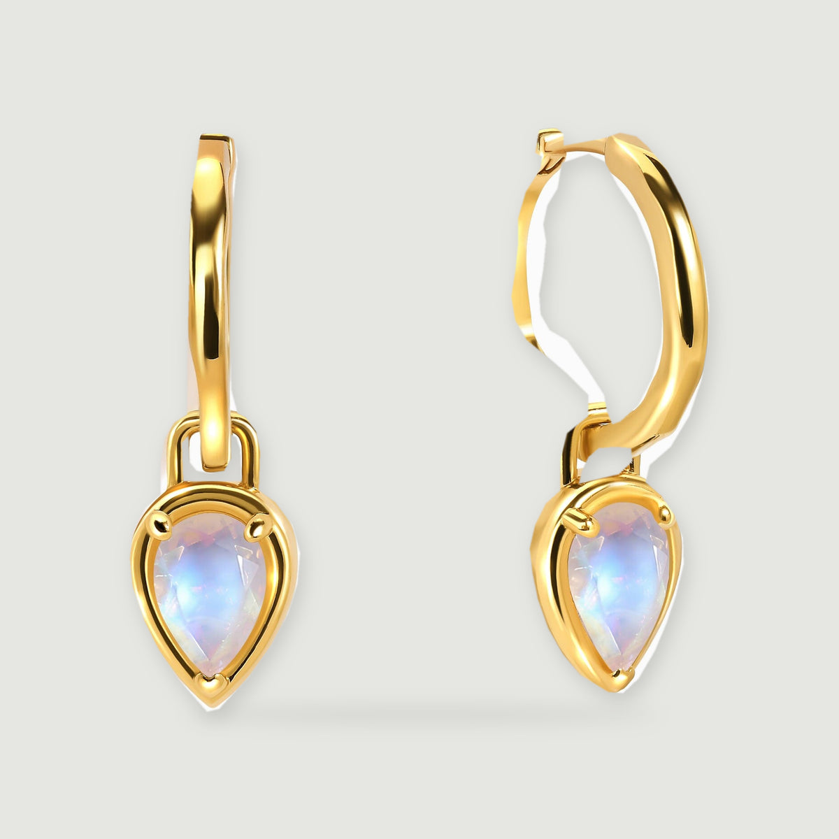 A pair of yellow-gold-tone hoops is shown with faceted pear-shaped moonstones and soft shadows.