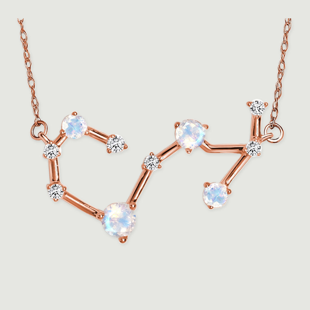 The complete angular pendant and its connecting chain links lie against a pale gray surface.