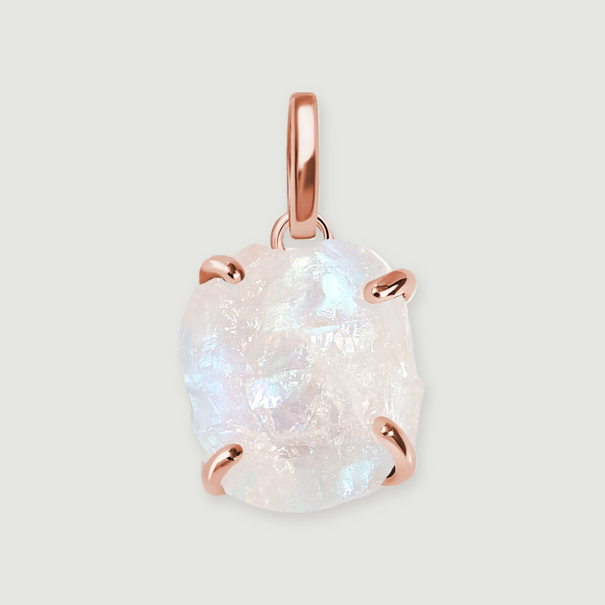 A raw moonstone pendant with four rose gold prongs and an elongated bail rests on a light gray background.