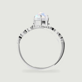 The white gold ring is shown from the side, revealing the raised moonstone setting and the open band.