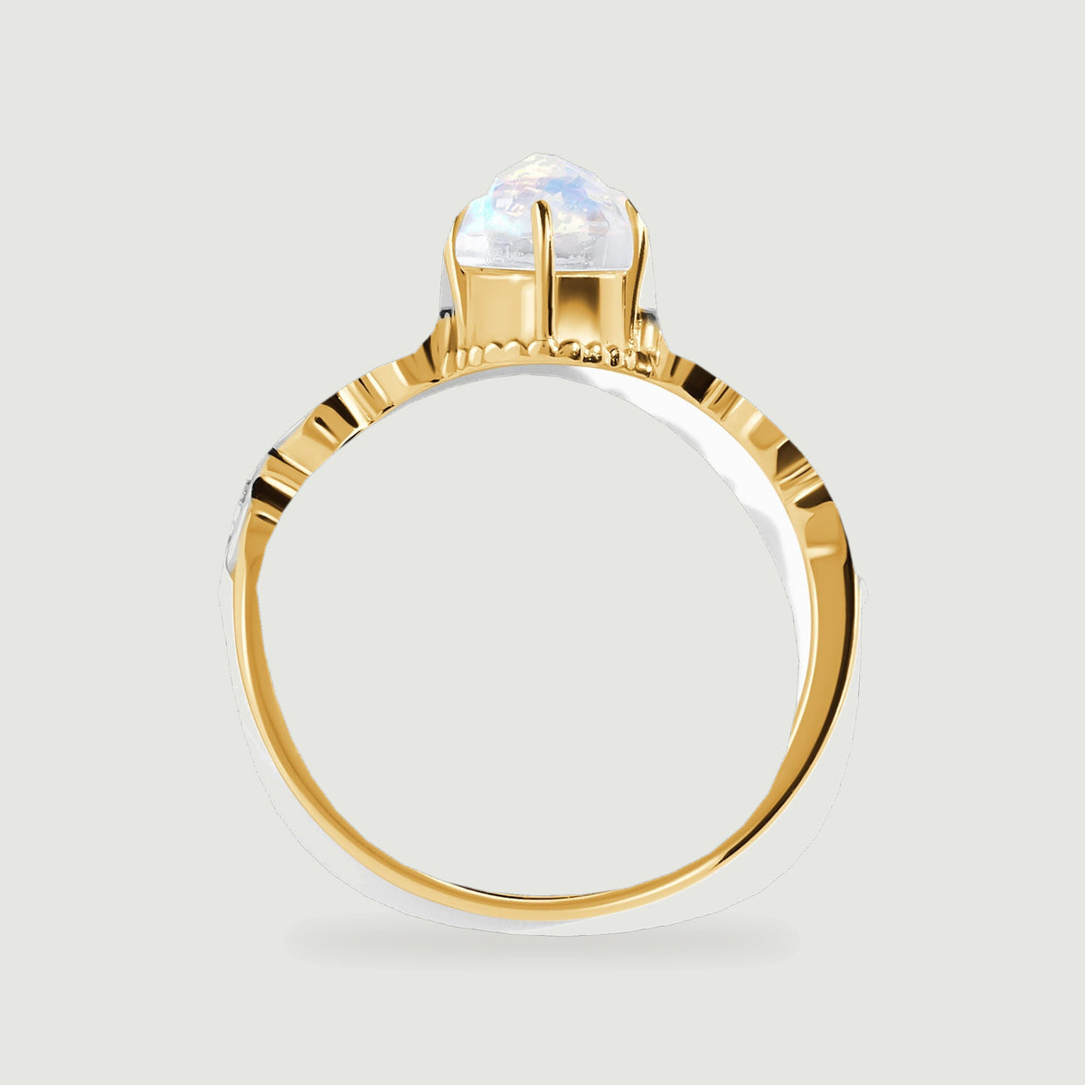 The yellow gold ring is viewed in profile with the moonstone basket rising above the diamond shoulders.