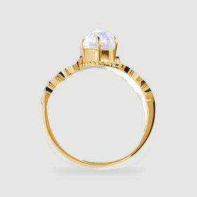 The yellow gold ring is viewed in profile with the moonstone basket rising above the diamond shoulders.