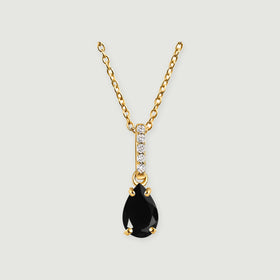 A yellow gold vermeil necklace with black onyx and a five-stone diamond bail is centered against light gray.