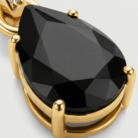 An angled detail reveals the raised gold prongs and open gallery underneath the faceted black onyx stone.