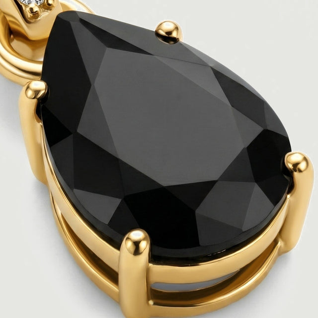 An angled detail reveals the raised gold prongs and open gallery underneath the faceted black onyx stone.