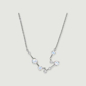 A silver chain frames a curved constellation of four round moonstones and small clear stones on a light gray background.
