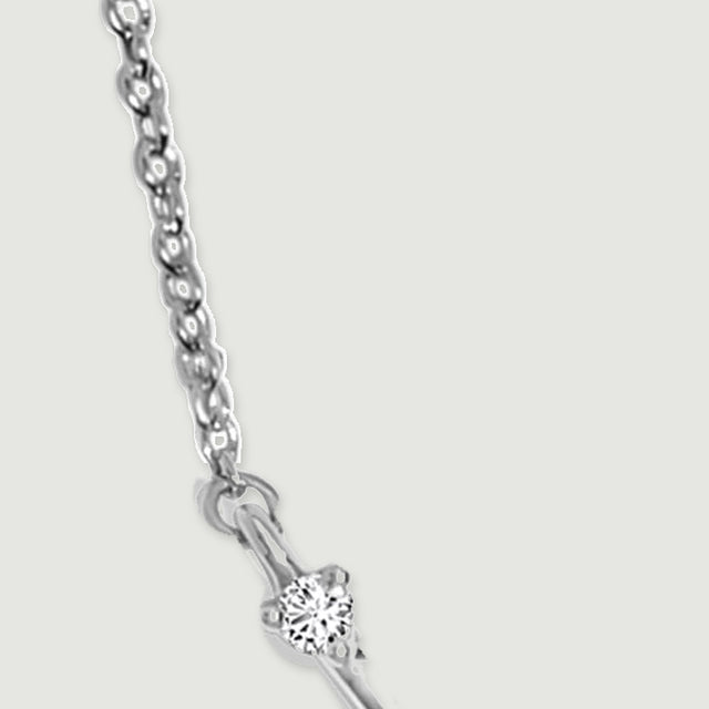 Oval silver chain links lead to a circular connector and a clear stone at the pendant tip.