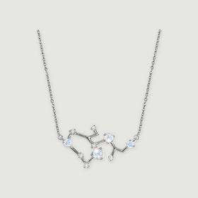 A silver necklace has four iridescent round stones and small clear stones along an angular pendant on a light gray background.