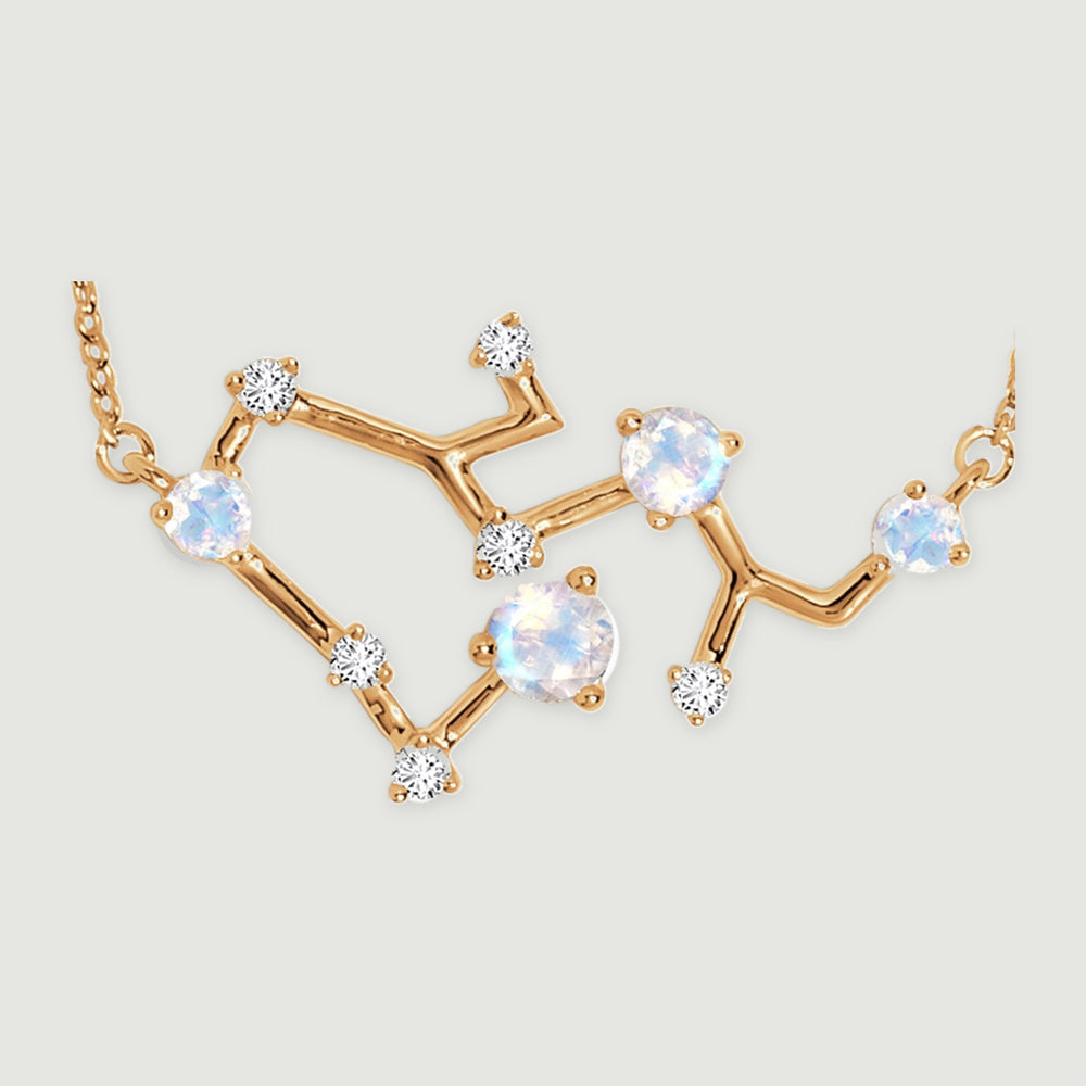 A close view shows polished yellow gold branches, round blue-white stones, and small clear accents in prong settings.
