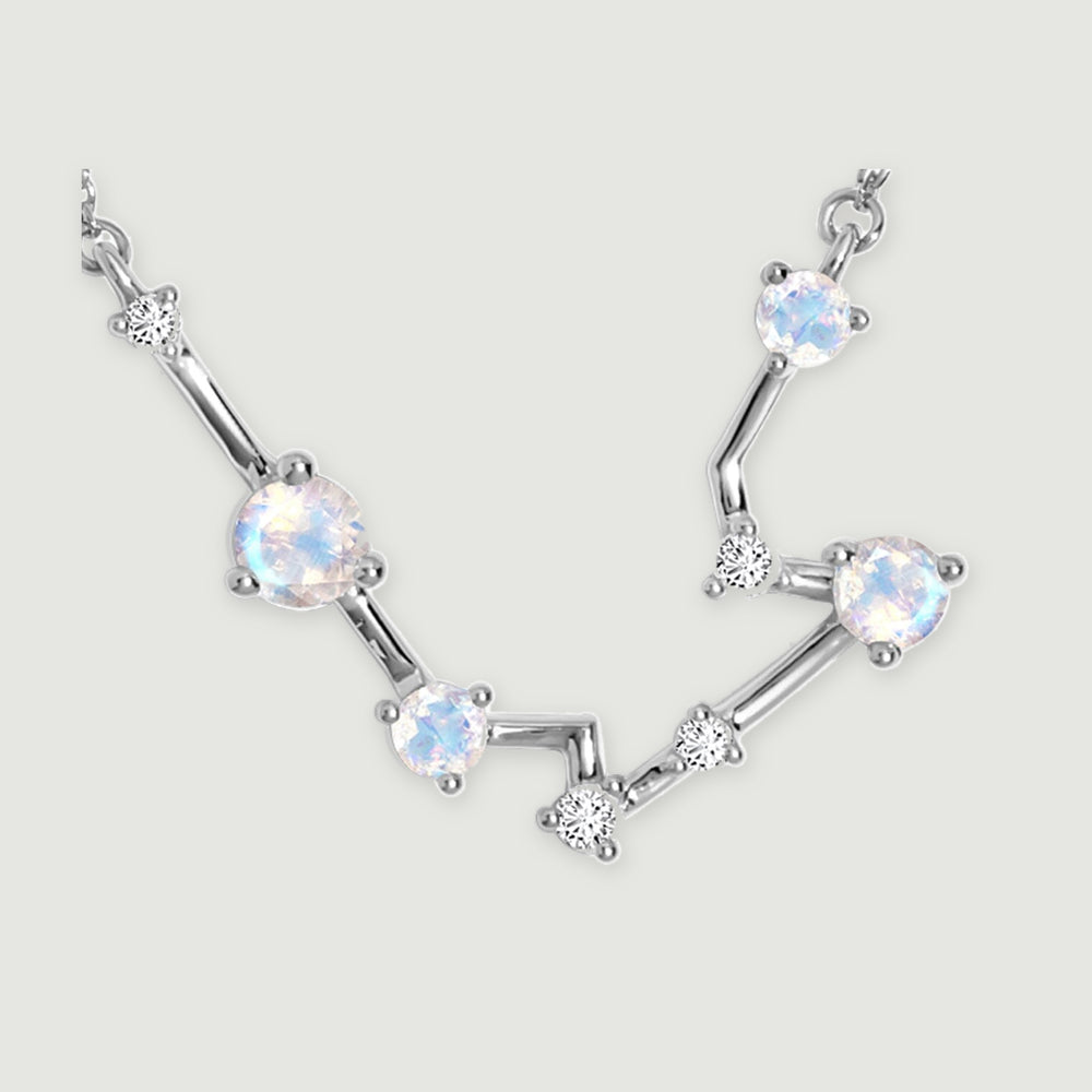 A close view reveals silver prongs around the round moonstones and the smaller clear stones along the angular links.