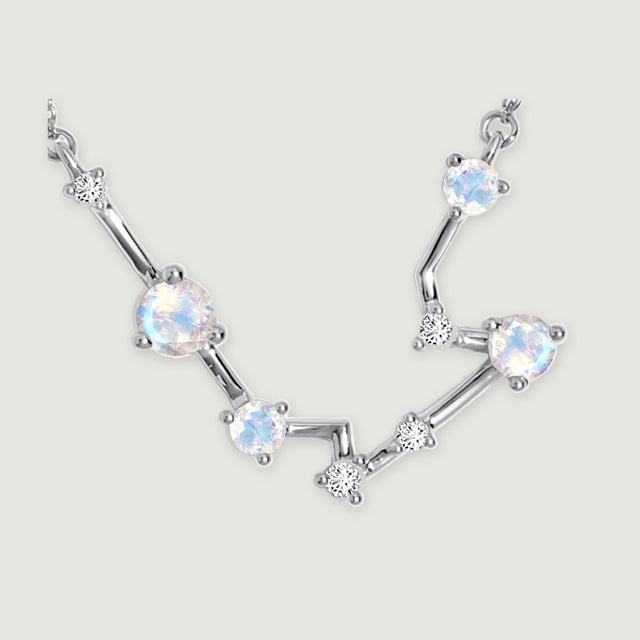 A close view reveals silver prongs around the round moonstones and the smaller clear stones along the angular links.