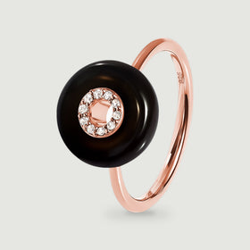 A rose gold vermeil ring features a glossy black round stone and a clear stone halo above its slim band.
