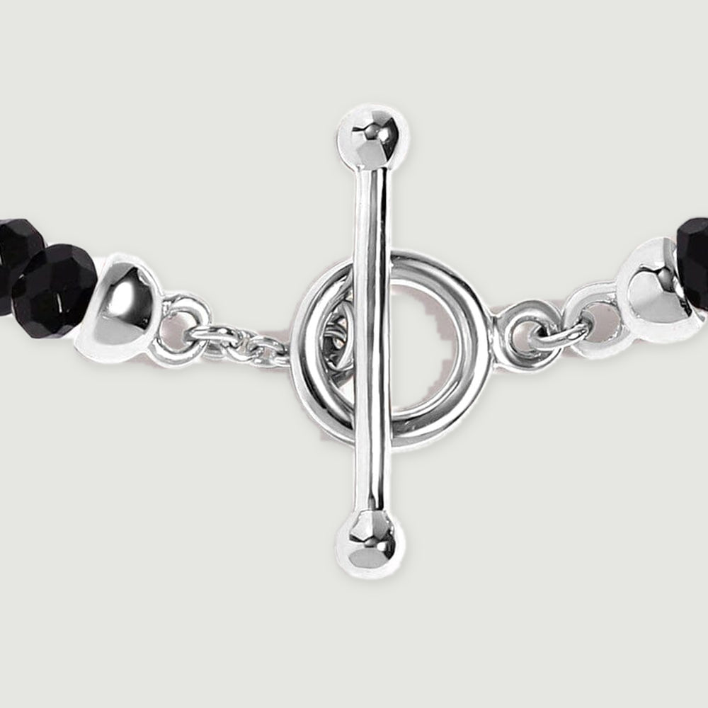 A close view shows the silver toggle bar, circular clasp, small connecting links, and adjacent faceted black beads.