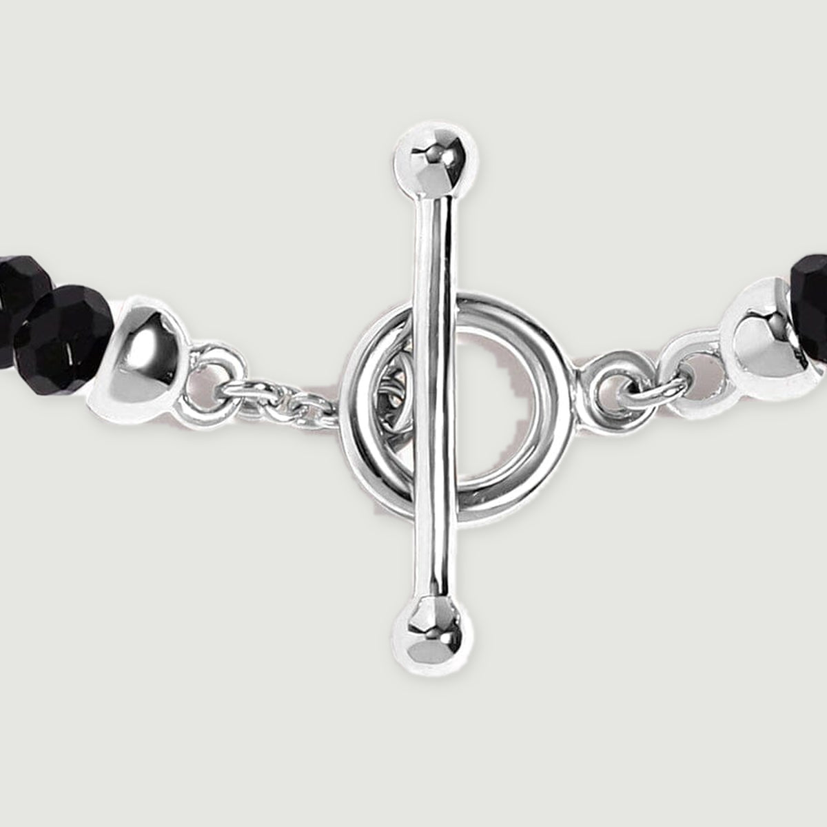 A close view shows the silver toggle bar, circular clasp, small connecting links, and adjacent faceted black beads.